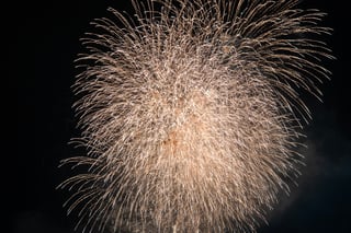 A fireworks display in the night sky, with bright white and yellow colors, creating a dazzling spectacle.