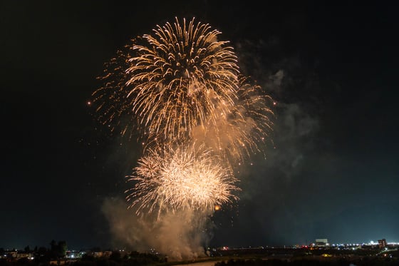 A fireworks display in the night sky, with bright lights illuminating the sky and city below.