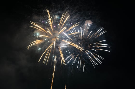 A fireworks display in the night sky, with bright fireworks and a long stream of light.