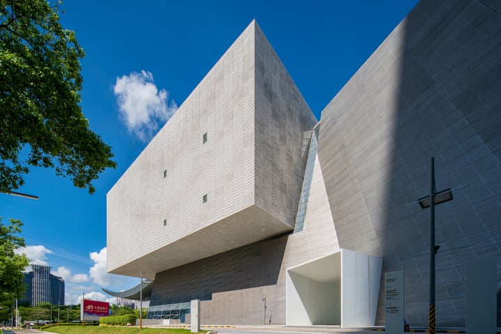 The image showcases a modern architectural marvel, a large, rectangular concrete building with a flat roof and a large, square opening at the top. The building is surrounded by lush greenery and a clear blue sky. The perspective of the photo is from a low angle, emphasizing the building's imposing presence. The image code "sa_17007" could be a reference to the specific image or series.