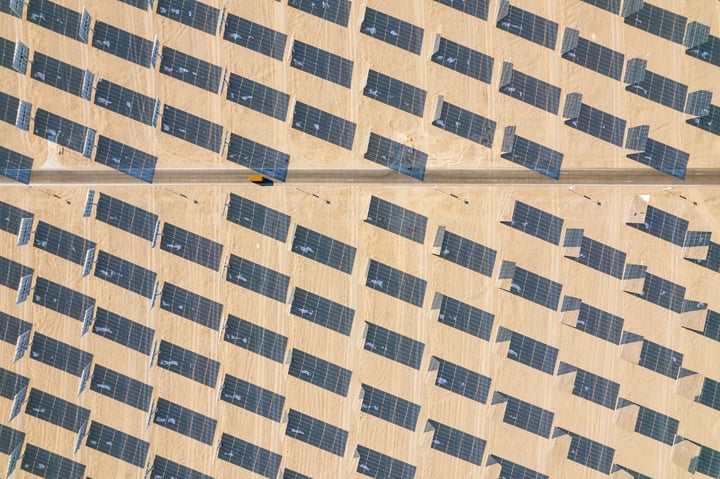 An aerial view of a solar-powered building with a grid-like pattern of houses, each with a solar panel, on a wooden structure.