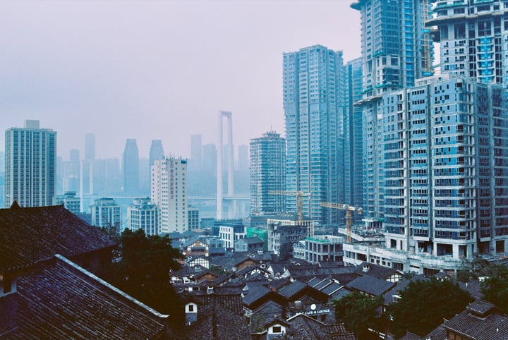 A cityscape with tall buildings, a bridge, and a crane in the background.
