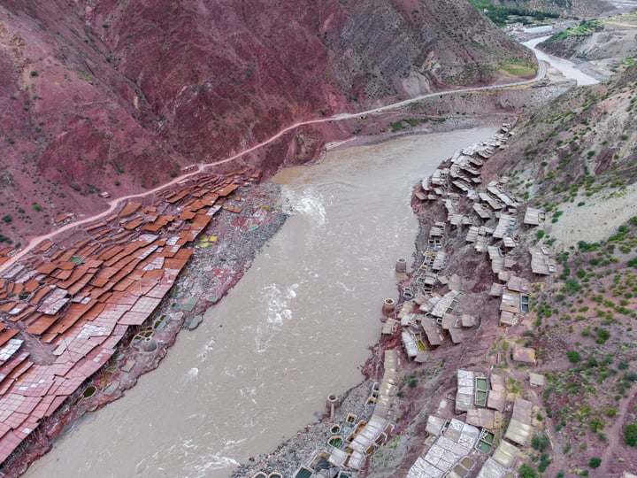 A traditional salt drying field in Markam, Tibet. Brine is placed in segmented salt drying pools, where the water gradually evaporates, leaving behind the salt. The brine, rich in minerals, gives the water a vermilion color.