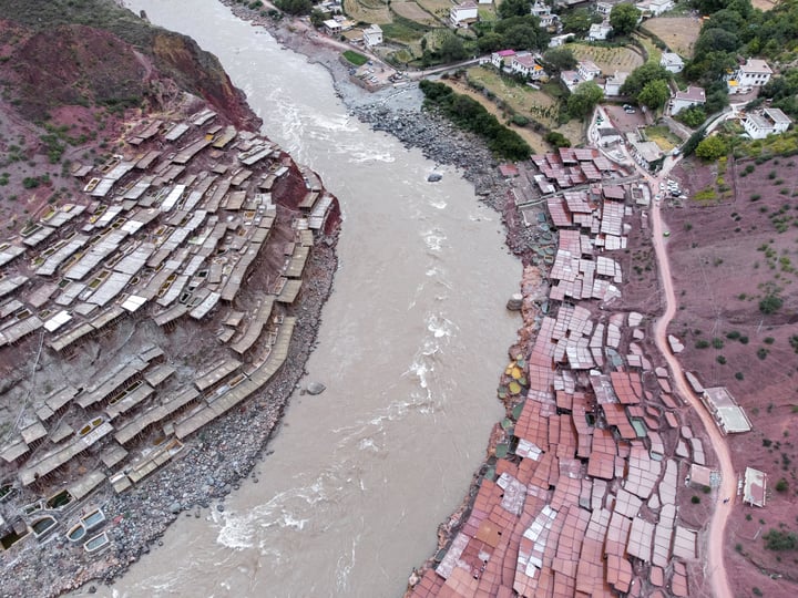 A traditional salt drying field in Markam, Tibet. Brine is placed in segmented salt drying pools, where the water gradually evaporates, leaving behind the salt. The brine, rich in minerals, gives the water a vermilion color.