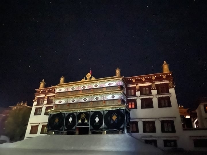 A large, ornate building with intricate decorations and a starry night sky in the background.